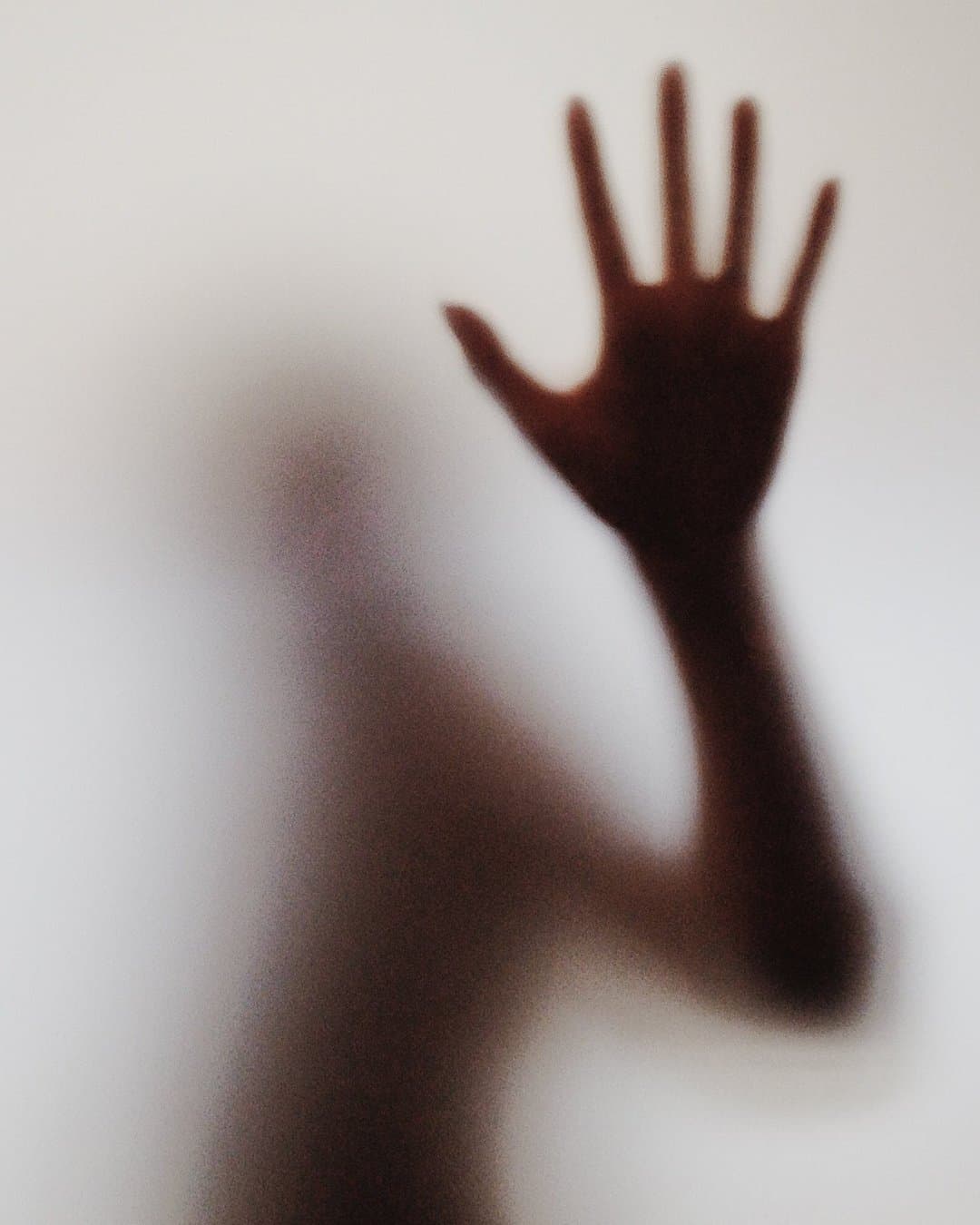Hand reaching through frosted glass