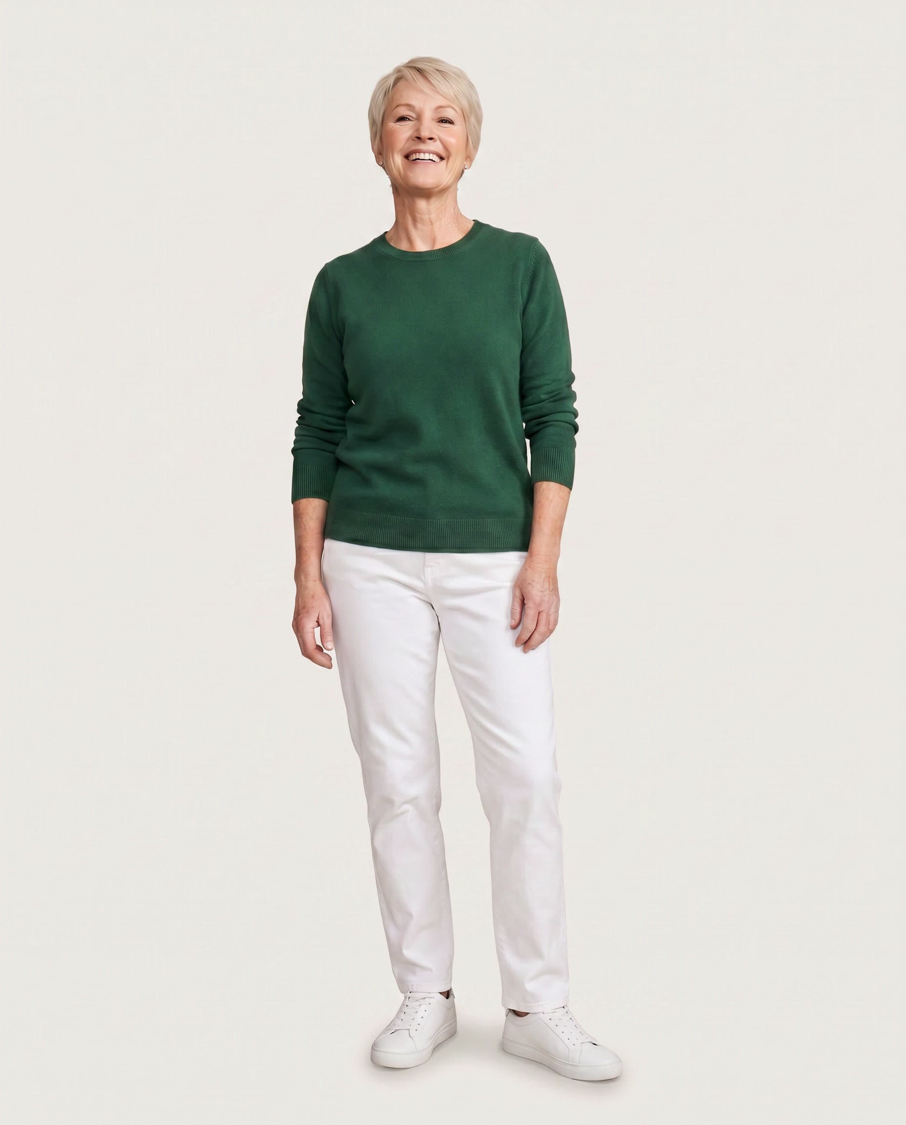 Woman with short blonde hair in a forest-green jumper