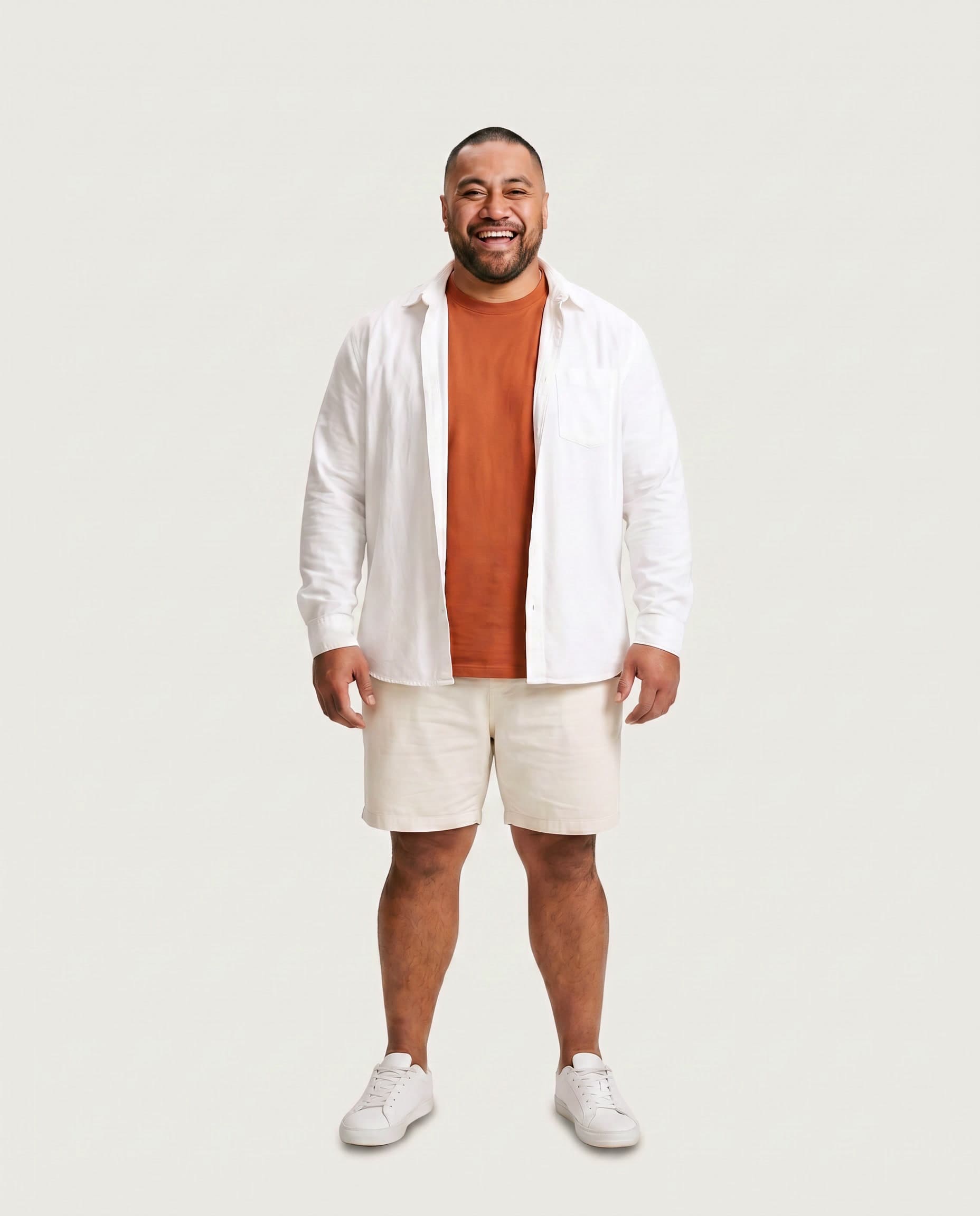 Man laughing in a tangerine tee and white overshirt
