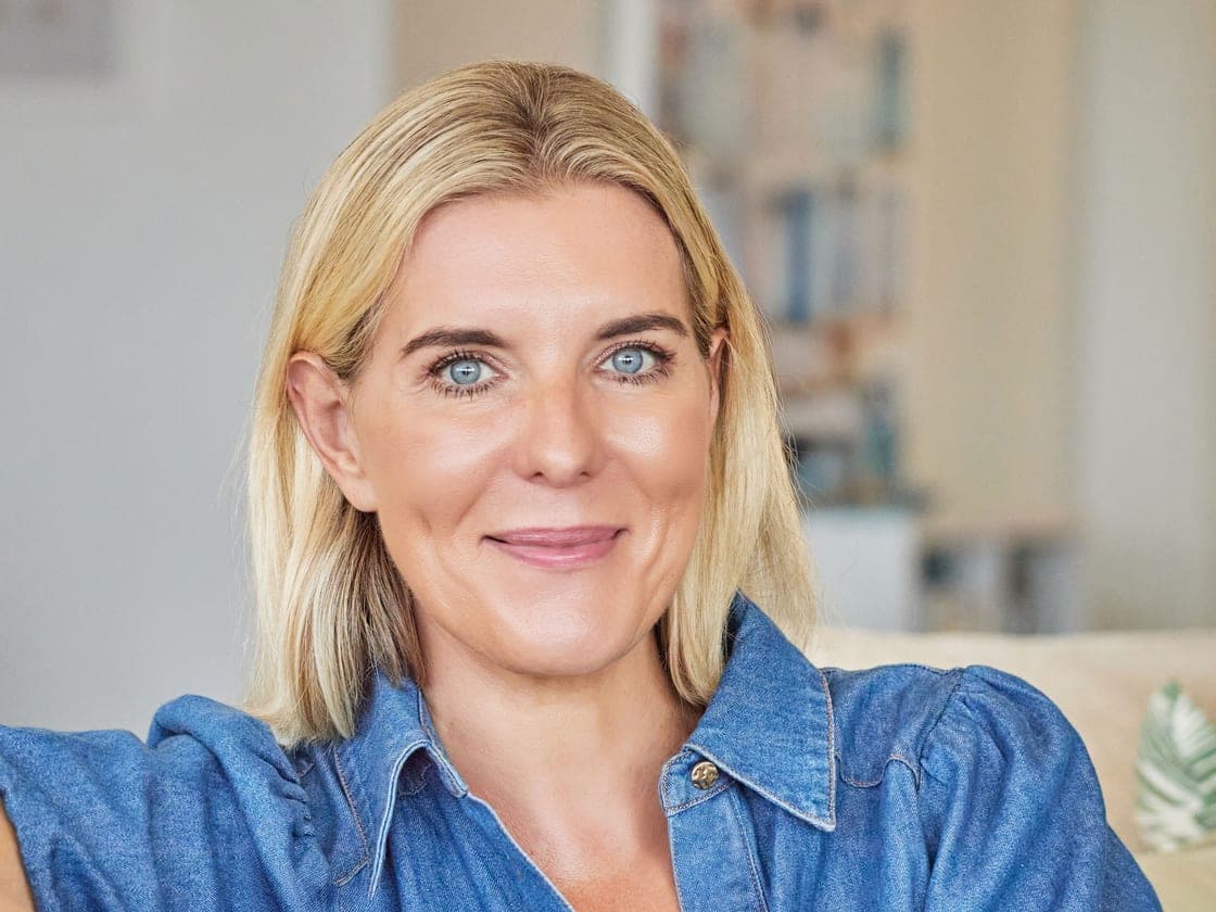 Camilla Thompson in a denim shirt, looking to camera.